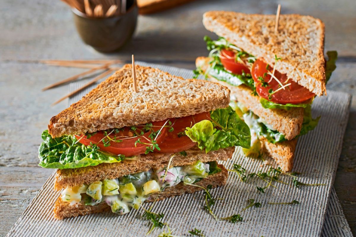 Doppeldecker-Sandwich mit Salat, Tomaten und einer Gurken-Dill-Mayonnaise-Schicht