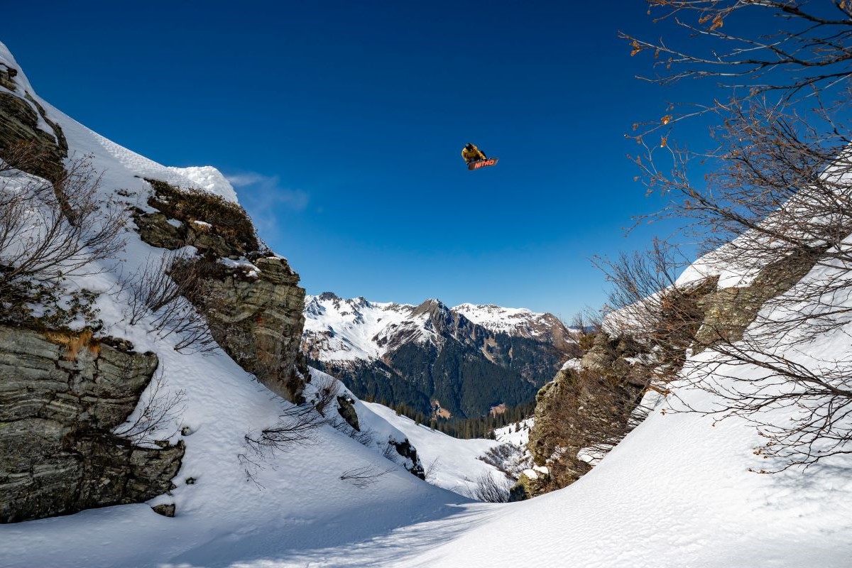 Thomas Feurstein fliegt auf seinem Snowboard über eine kleine Schlucht hinweg